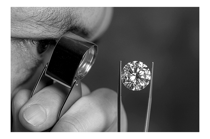Gemologist verifying a diamond with a loupe before export paperwork is prepared